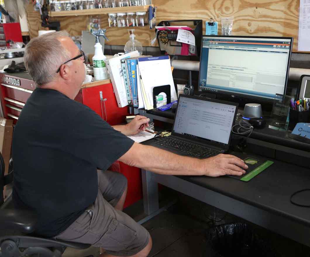 RV service technician working on service software on a computer.