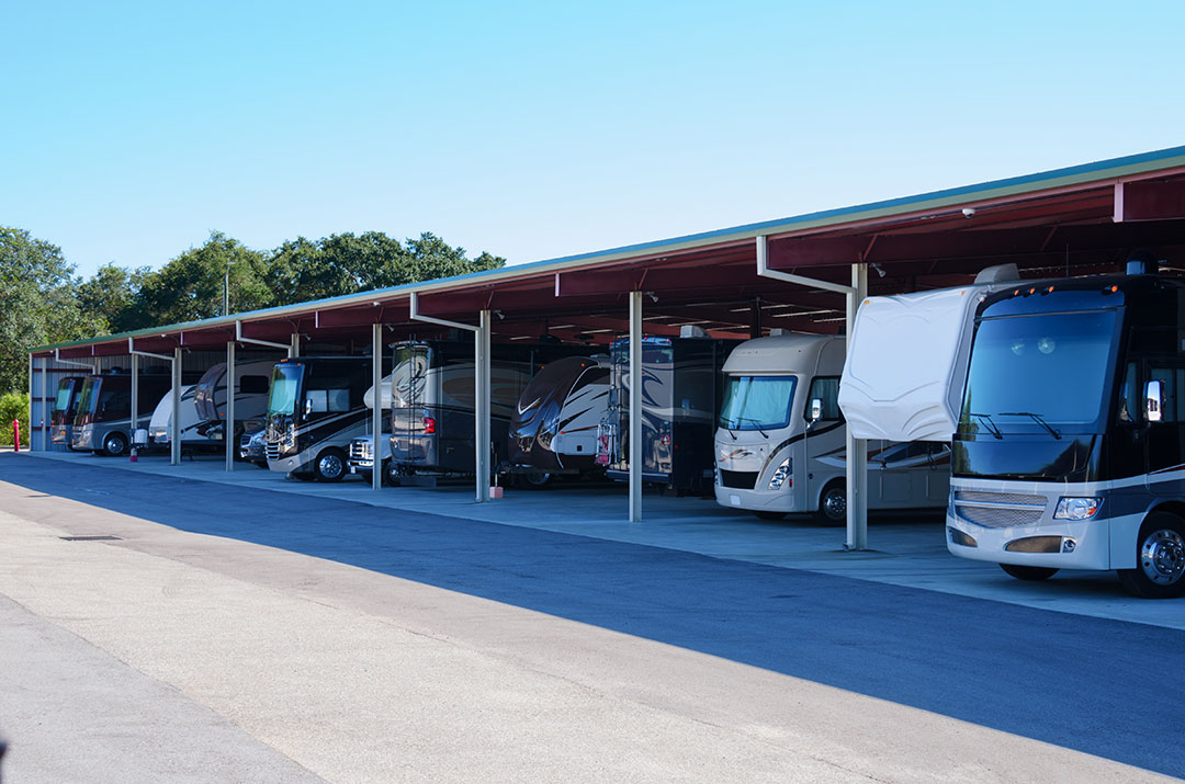 Several RVs parked under a garage with a roof