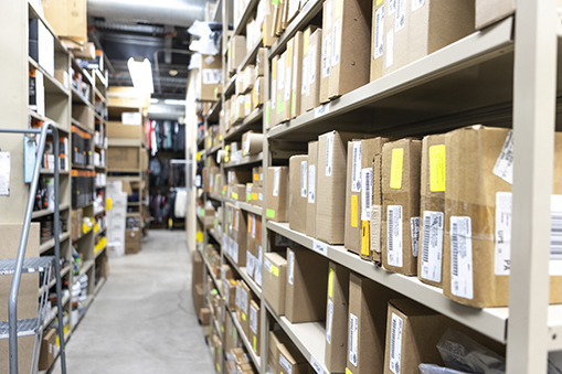 Image of shelves in a warehouse containing boxes of parts.